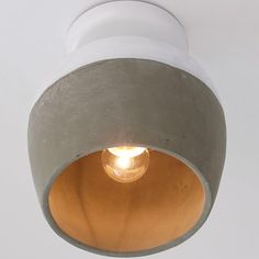 a light that is on the side of a white wall with a small light bulb