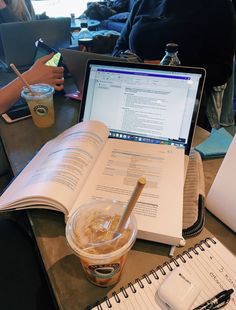 an open book sitting on top of a table next to a laptop computer