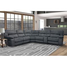 a large sectional couch in a living room with wood flooring and gray rugs