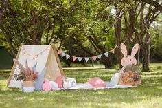 a teepee tent set up in the grass with bunting and flowers