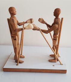 two wooden mannequins standing next to each other