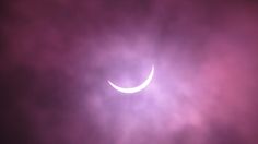 the moon is partially obscured by clouds during a solar eclipse