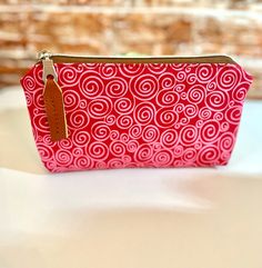 A swirly beauty zipper pouch of red rasberry and pink with a touch of brown faux leather that is truly great for kids, teens and adults. Useful for a variety of neccessities:  school or work accessories, glasses, feminine products, etc.. of endless usage. Zipper Box pouch is made with cotton fabric (front) / Faux leather (back) and waterproof canvas lining. Nylon Coil Zipper. Dimensions: Length: 7.5 inches x Height: 4 inches Pens, markers or sunglasses are not included with pouch. Zipper Box Pouch, Feminine Products, Work Accessories, Box Pouch, Accessories Glasses, Pencil Pouch, Zipper Pouch, Labour Day, Markers