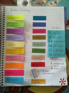 a spiral notebook with colorful sticky notes attached to the pages that are labeled in different colors