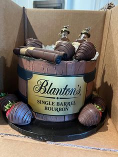 a cake in the shape of a barrel with chocolate covered strawberries