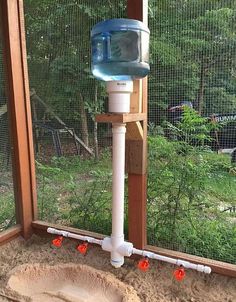 a water dispenser on the side of a window sill in an enclosure