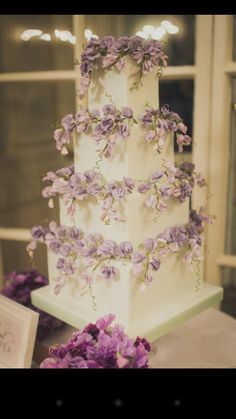 a wedding cake with purple flowers on it