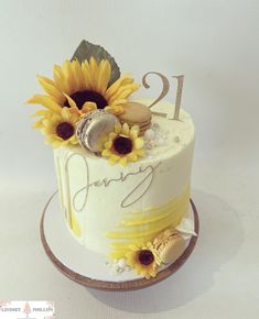 a white cake with sunflowers on it and the number twenty one is decorated