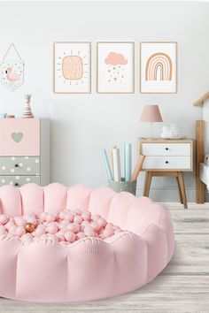 a pink bean bag chair in a child's room with pictures on the wall