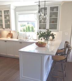 a kitchen with white cabinets and an island