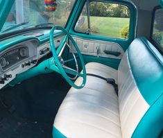 the interior of an old car with blue and white leather upholstered seat covers