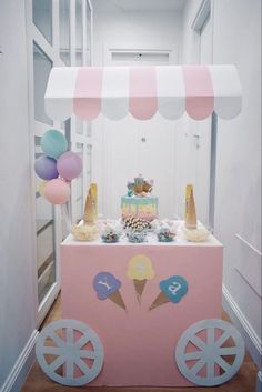 an ice cream cart is decorated with balloons and confetti for a birthday party