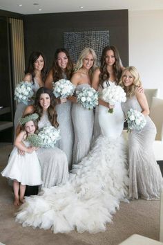 the bride and her bridal party are posing for pictures in their wedding gowns