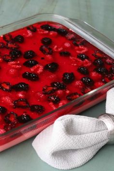 a casserole dish with berries in it and a white napkin next to it