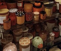 many jars are stacked on top of each other in this display case at the store