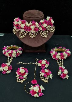 pink and white flowers are on display in front of a mannequin