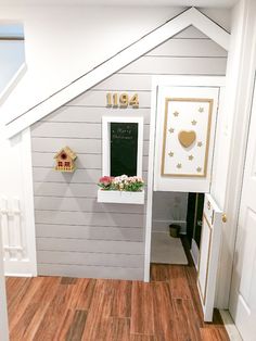 the interior of a dollhouse with white walls and wood floors