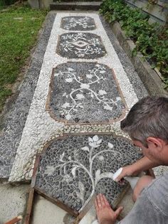 a man is working on a mosaic in the garden