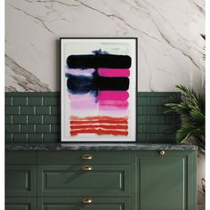 an abstract painting hangs on the wall above a green cabinet in a room with marble walls