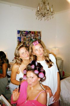 three young women are posing for the camera in their bedroom with one woman holding her hair