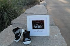 a pair of black and white sneakers sitting next to a photo frame with the words love at first sight