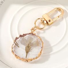 a white plate with a gold key chain and a flower in the center on it