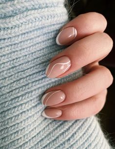 a woman's hand with french manies on her nails and a blue sweater