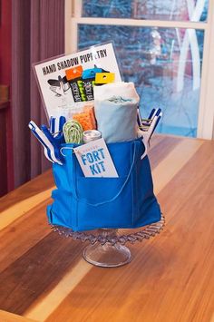 a blue bag filled with items sitting on top of a wooden table