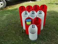 a set of cups with numbers on them sitting in the grass next to a car