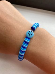 a person wearing a bracelet with a smiley face on it