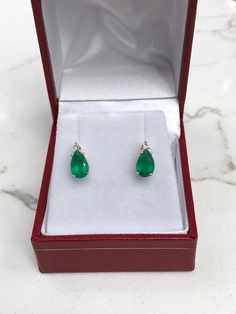 Elegance defined! These teardrop emerald and diamond earrings are fashioned in solid 14k yellow gold. These studs feature genuine Brazilian emeralds accented with natural white diamonds. The emeralds have a combined 1.60 total carat weight and a medium green hue that contrasts with the flashing fire of the diamonds. The brilliant round diamonds have a combined 6 points. Setting Style: Emerald & Diamond Studs Setting Weight: 2.0 grams Setting Material: 14K Yellow Gold Main Stone: Brazilian Em Teardrop May Birthstone Earrings, Fine Jewelry Pear-shaped May Birthstone Earrings, Fine Jewelry Pear-shaped Earrings For May Birthstone, Green Teardrop Earrings With Prong Setting, Emerald And Diamond Earrings, Emerald Earrings Studs, Earrings Teardrop, May Birthstone, Diamond Stud Earrings