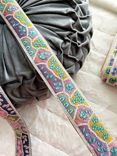 a close up of a colorful ribbon on a white surface with other items in the background