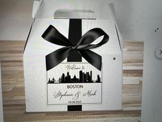 a white box with a black bow on the front and bottom that says welcome to boston