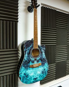 an acoustic guitar is hanging on the wall