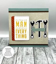 a card with the words man and two wrenches on it, sitting on top of a wooden table