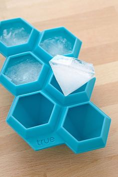 ice cubes are arranged in the shape of hexagons on a wooden surface