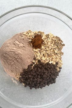 three different types of food are in a glass bowl on the counter top, including oatmeal, chocolate chips, and peanut butter