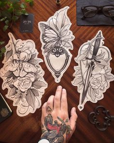 a person with tattoos on their hands next to some stickers and scissors in front of them