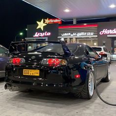 a black car parked in front of a gas station