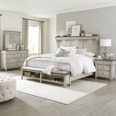 a bedroom with a bed, dresser and mirror