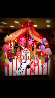 a circus themed birthday centerpiece with balloons and confetti on the top,