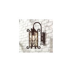 an old fashioned wall light on the side of a white brick wall with wrought iron accents