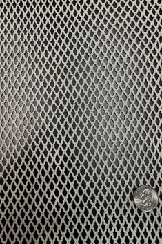 a close up view of a metal surface with small holes in the middle and an oval hole at the center