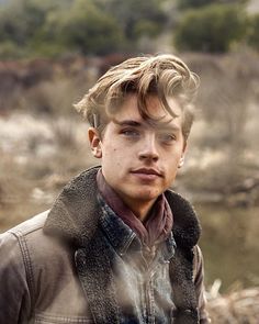 a young man with blonde hair wearing a jacket