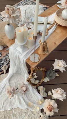 the table is set with candles, plates and other items on top of an old rug