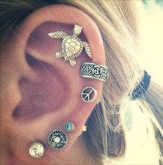 the ear is adorned with several different types of buttons and charms, as well as a turtle