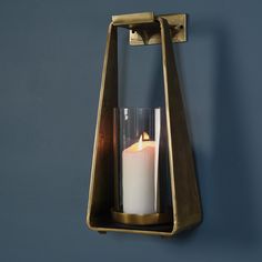 a candle that is sitting in a holder on the wall next to a blue wall