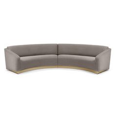 the curved sectional sofa is made from grey fabric and has gold trimmings on it