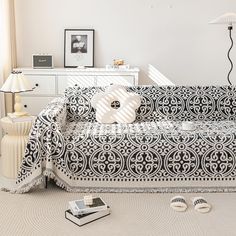 a living room with white furniture and black and white patterns on the couches,