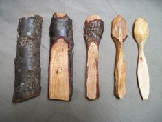 five wooden spoons are lined up next to each other